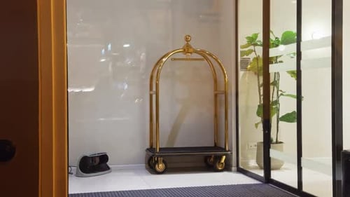 An Elegant Hotel Lobby Featuring a Stylish Bellman Cart and Lush Greenery Enhances the Ambiance