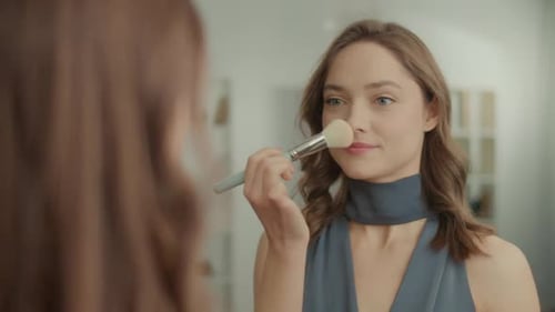 Back View of Pretty Woman Applying Powder with a Brush in Front of the Mirror