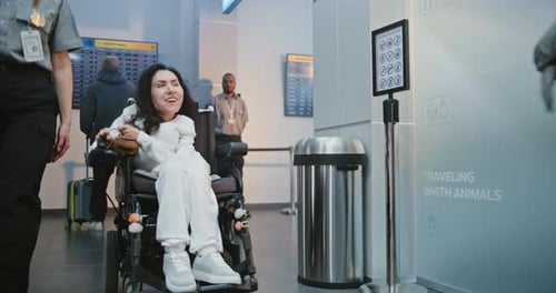 Security Worker Walks with Woman with Physical Disability to Security Checkpoint in Airport Terminal