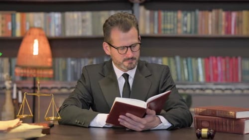 Middle Aged Lawyer Reading Book in Office