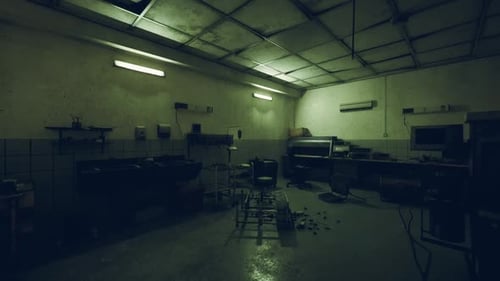 Desolate Industrial Kitchen with Dim Lighting and Scattered Clutter at Night