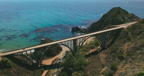 Sightly arched bridge for transport between the mountains on the coast of Pacific.
