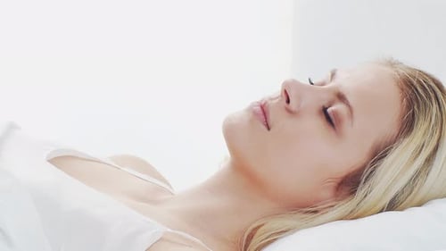 Woman Relaxing with Eyes Closed in Bed