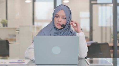 Arab Woman with Headset Talking Online with Customer in Call Center