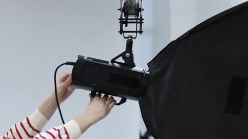 Woman with professional lighting equipment in photo studio, closeup