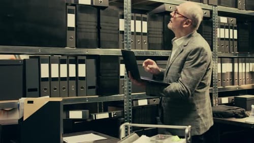 Man and Woman Analyze Files in Workspace