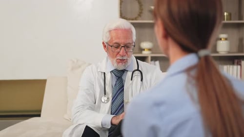 Senior Man Doctor Examining Young Woman in Doctor Office Clinic or at Home Girl Patient and Doctor
