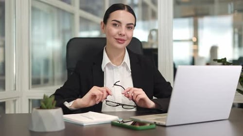Female Entrepreneur Using Digital Devices While Holding Glasses in Office