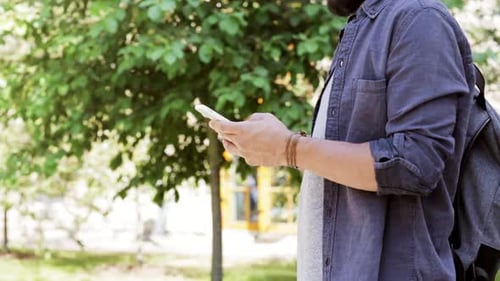 Man Using Smartphone in Urban Park Setting