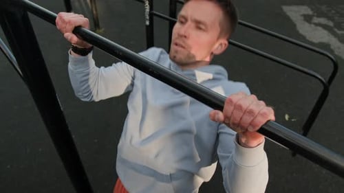 Young Man Doing Pull-Ups in Outdoor Training Area