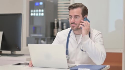Young Doctor Talking on Phone in Clinic