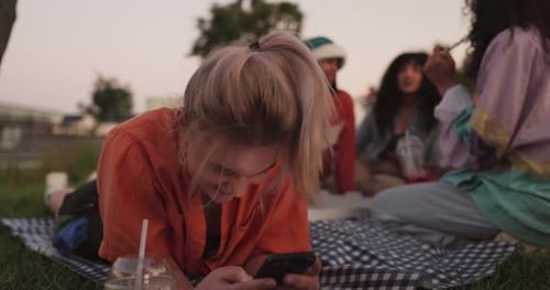 Friends Relaxing on Blanket in Urban Park