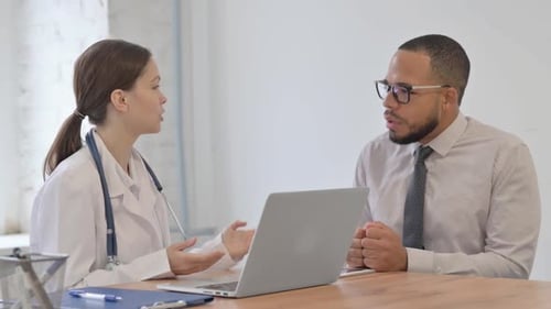 Female Doctor Talking with Patient in Hospital