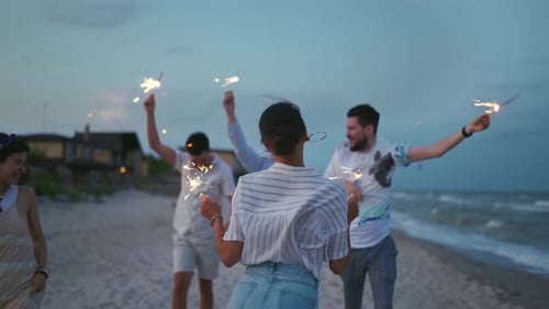 Friends Celebrate with Sparklers on Beach at Night