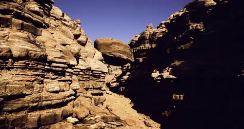 Dramatic Rock Formations in a Narrow Canyon Under Clear Blue Sky