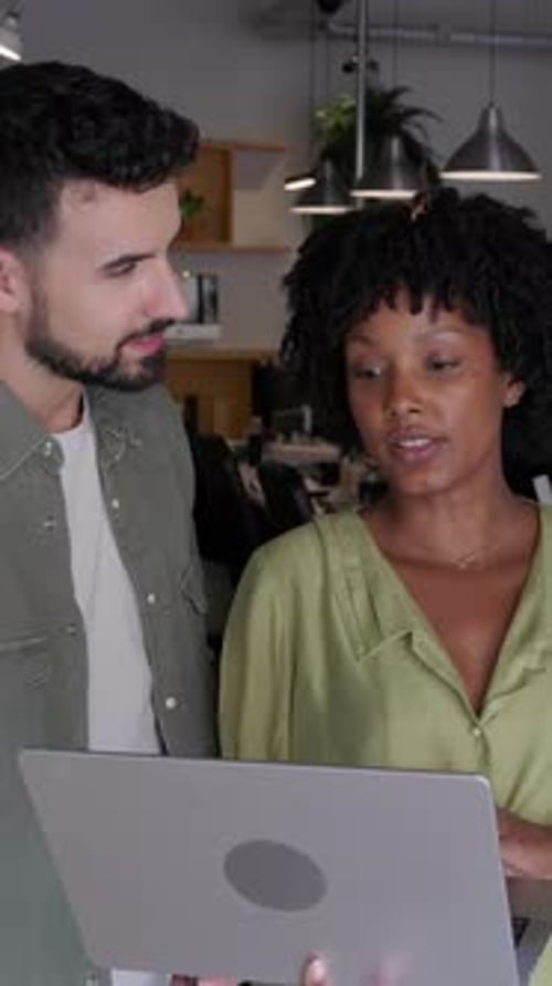Three Young Coworkers Collaborating on a Laptop in the Office