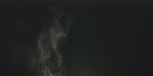 White Dust Particles Rising on Black Background