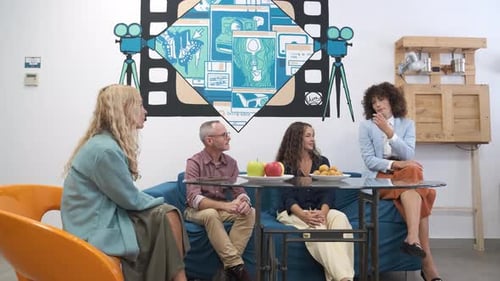 Businesspeople Chatting on Sofas in Modern Office