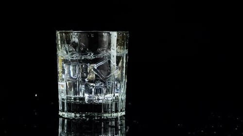 Ice Cubes Falling Into Glass of Water