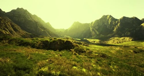 Green Valley Surrounded By Majestic Mountains During Golden Hour