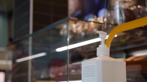 A Woman's Hand Takes an Antiseptic in a Dispenser