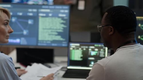 Diversos ingenieros de redes que se comunican en la sala de ciberseguridad