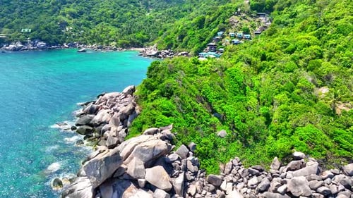 Stunning sandy beach with rock, clean sea water and green forest. 4K.