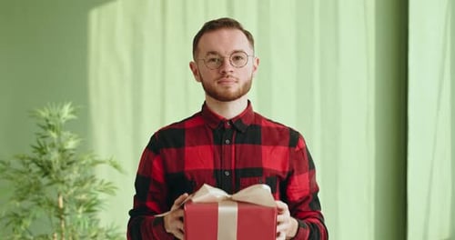 Smiling Man Extends Red Birthday Gift