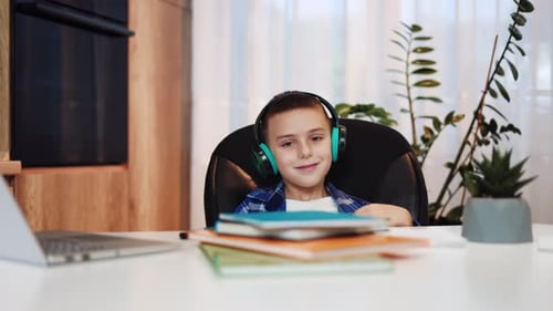 School Boy Listening Music in Headphones While Relaxing From Boring Homework