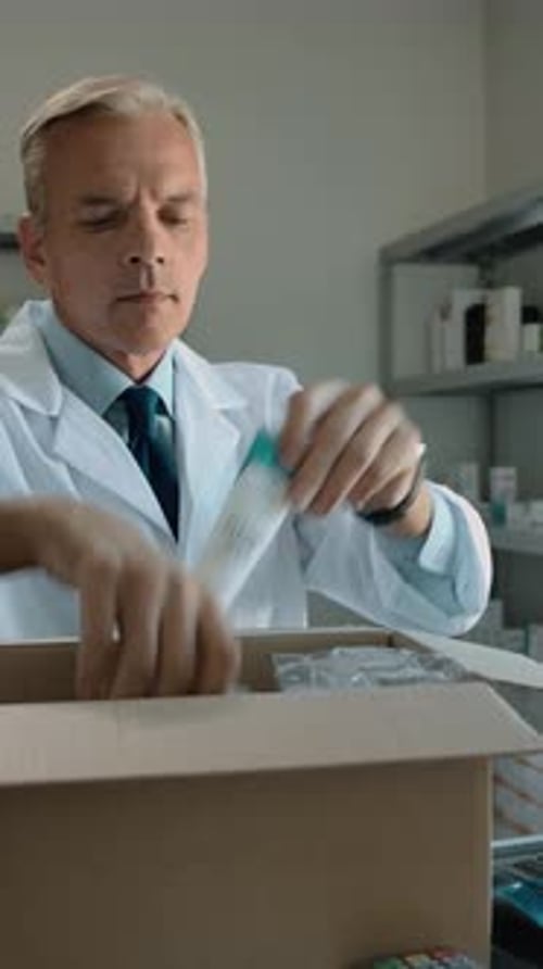 Vertical of Pharmacist Unpacking Delivery From Stock Indoor of Drug Store Interior