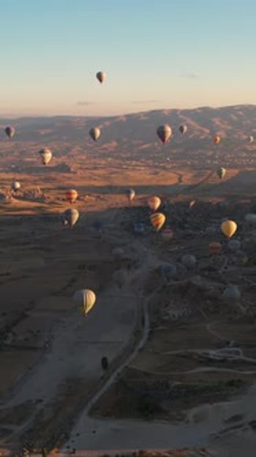 Vertical Drone Shot, Hot Air Balloons in Cappadocia Turkey at Sunrise, Flying Parachutes