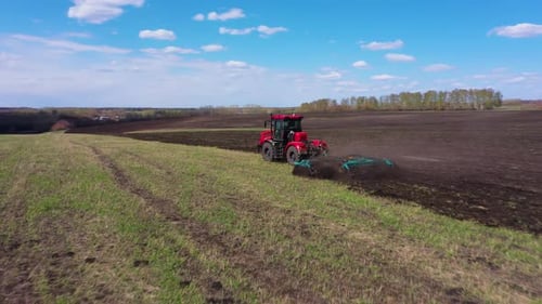 Red Tractor Working at Field