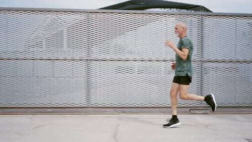 Senior Man Jogging Along Sidewalk