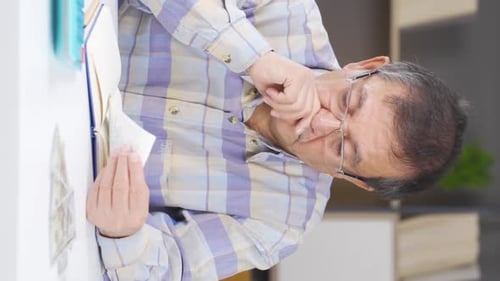 Senior Man Counting Money and Writing in Notebook