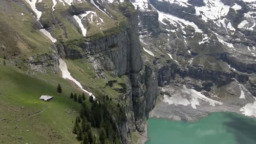 Lonely alm sitting on the verge of a steep cliff overlooking the Oeschinensee in Switzerland