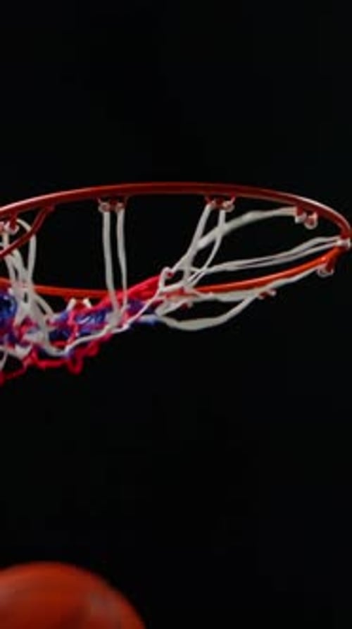 Basketball Swishing Through Net on Black Background