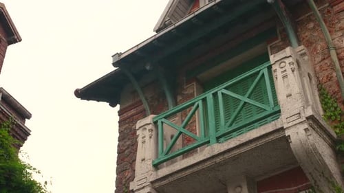 Beautiful vintage green balcony in the medieval Montsouris street, Paris. Picturesque old house faça
