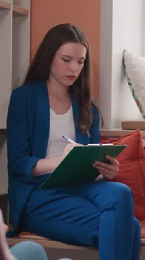 Young Woman Taking Notes on Clipboard Indoors