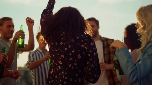 Friends Celebrate and Dance on Rooftop at Sunset
