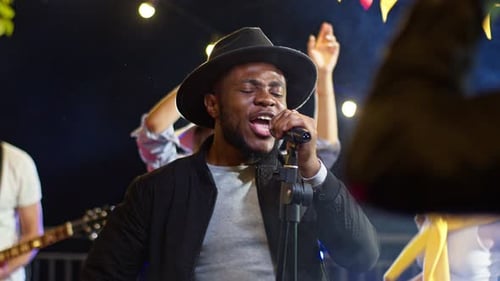 Singer Performing Live with Band at Night