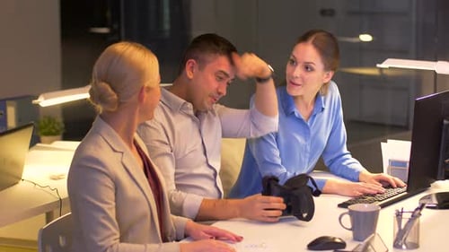 Team Discussing Technology at Office Desk at Night