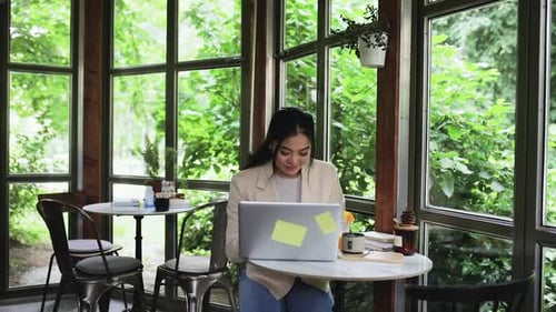 Young woman using laptop in coffee shop.