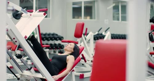 Woman Using Leg Press Machine at the Gym
