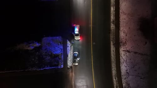 Aerial View Of City At Night With Traffic Police Car Stopping Vehicles