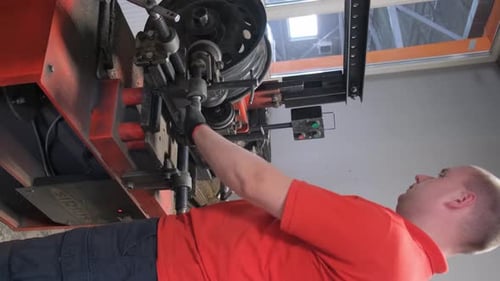 Ein Mechaniker repariert ein unebenes Fahrgestell in einem Auto | Autoservice | Vertikales Video