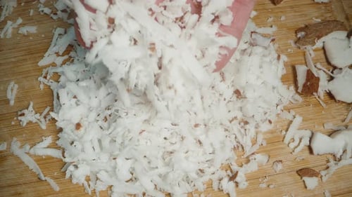 Freshly Grated Coconut Shavings Being Mixed in Male Hands. Top View.