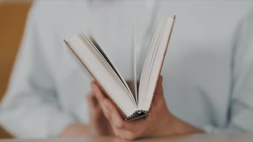 Woman closing old hardcover book in hands