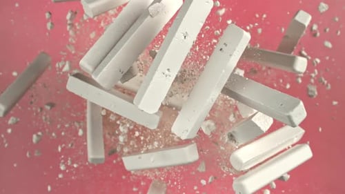 School Chalk Flying on a Pink Background Filmed on a Highspeed Camera at 1000 Fps