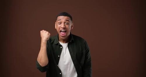 Successful African American Person Celebrating Victory Enjoying Success Standing Over Brown Studio
