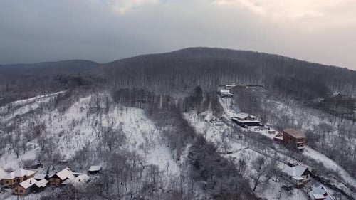 Aerial drone footage above a small village near a beautiful forest Holiday season with snow